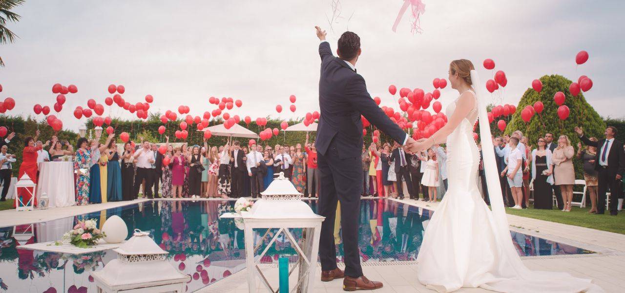 Scène de mariage avec un couple heureux sous une arche de fleurs, entouré de décorations élégantes et d'invités en fête, illustrant les services d'animation de DJ Val