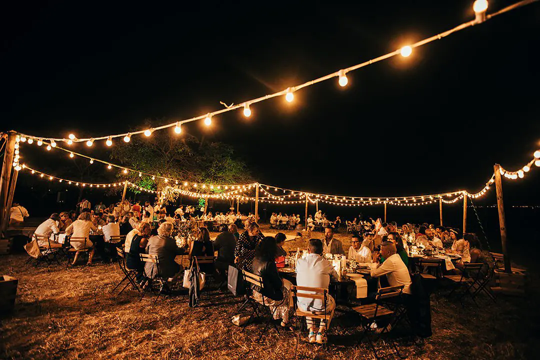 Repas festif sous des guirlandes guinguette en location à Avignon, créant une ambiance lumineuse et conviviale